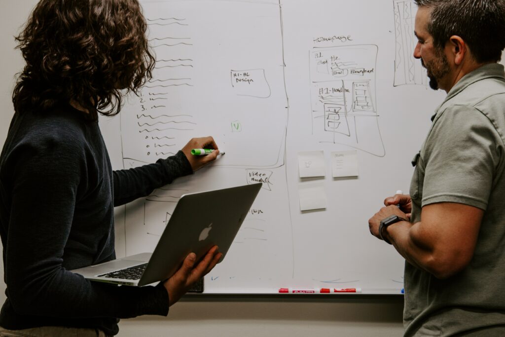 Entrepreneurship 101: Entrepreneurs brainstorming around a whiteboard