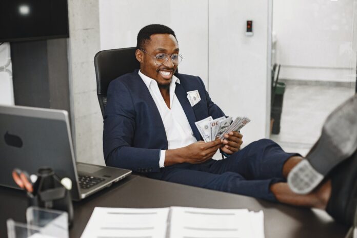 happy elegant man with money in office