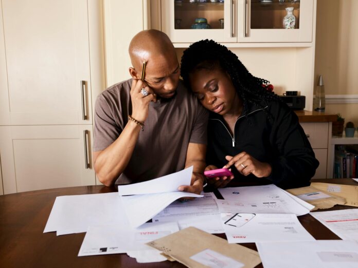 pexels-photo-14599250-1 couple sitting by table calculating expenses