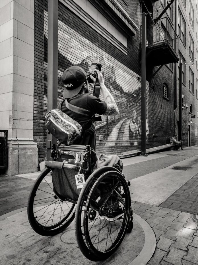 pexels-photo-27349879 man on a wheelchair photographing the street in black and white