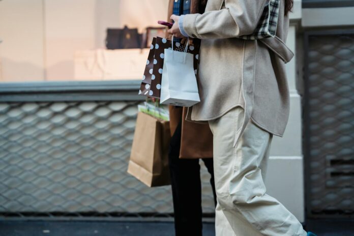 pexels-photo-6567370 crop faceless women with shopping bags and smartphone strolling on street